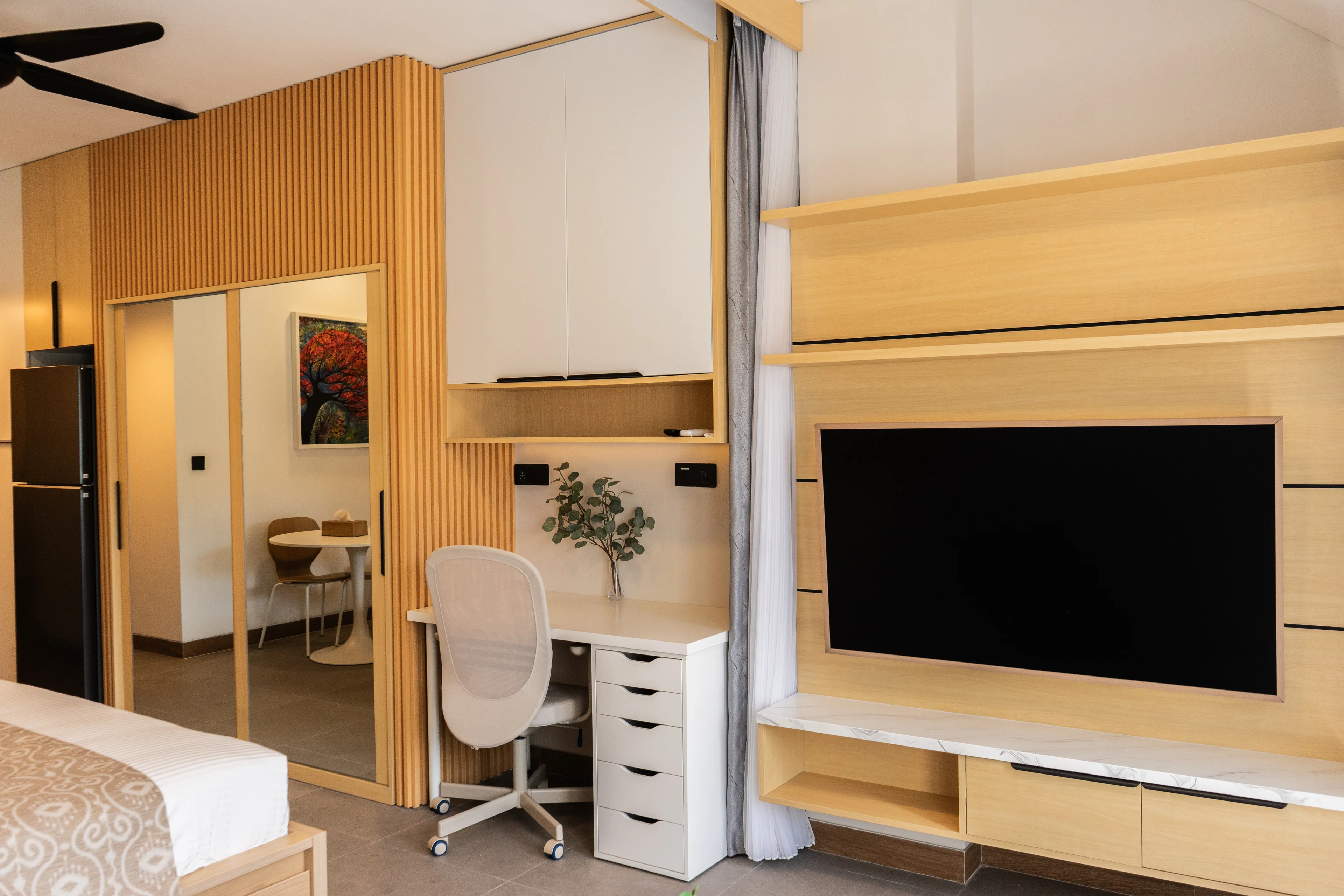 Study desk and television wall in a renovated de Lagoon residence, the wardrobe mirror alongside
