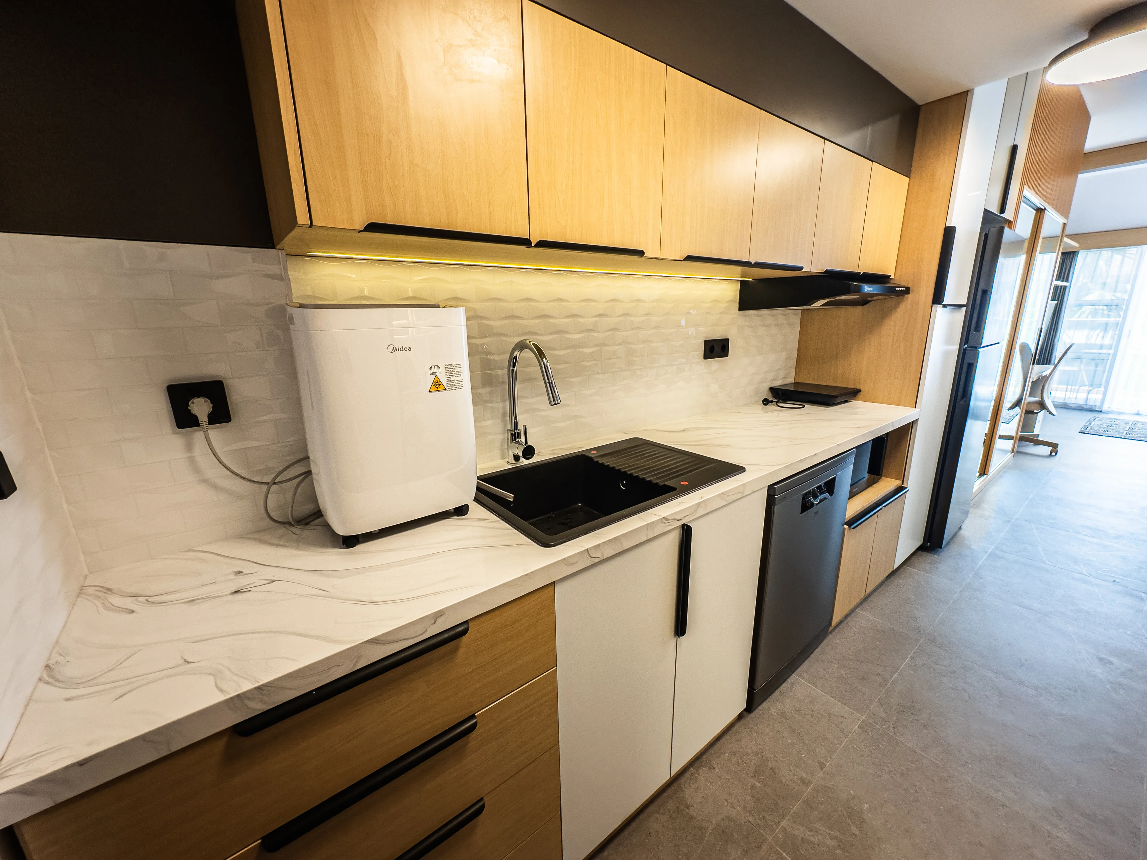 Kitchenette in a renovated de Lagoon residence, with sink, cooktop and under-bench fridge