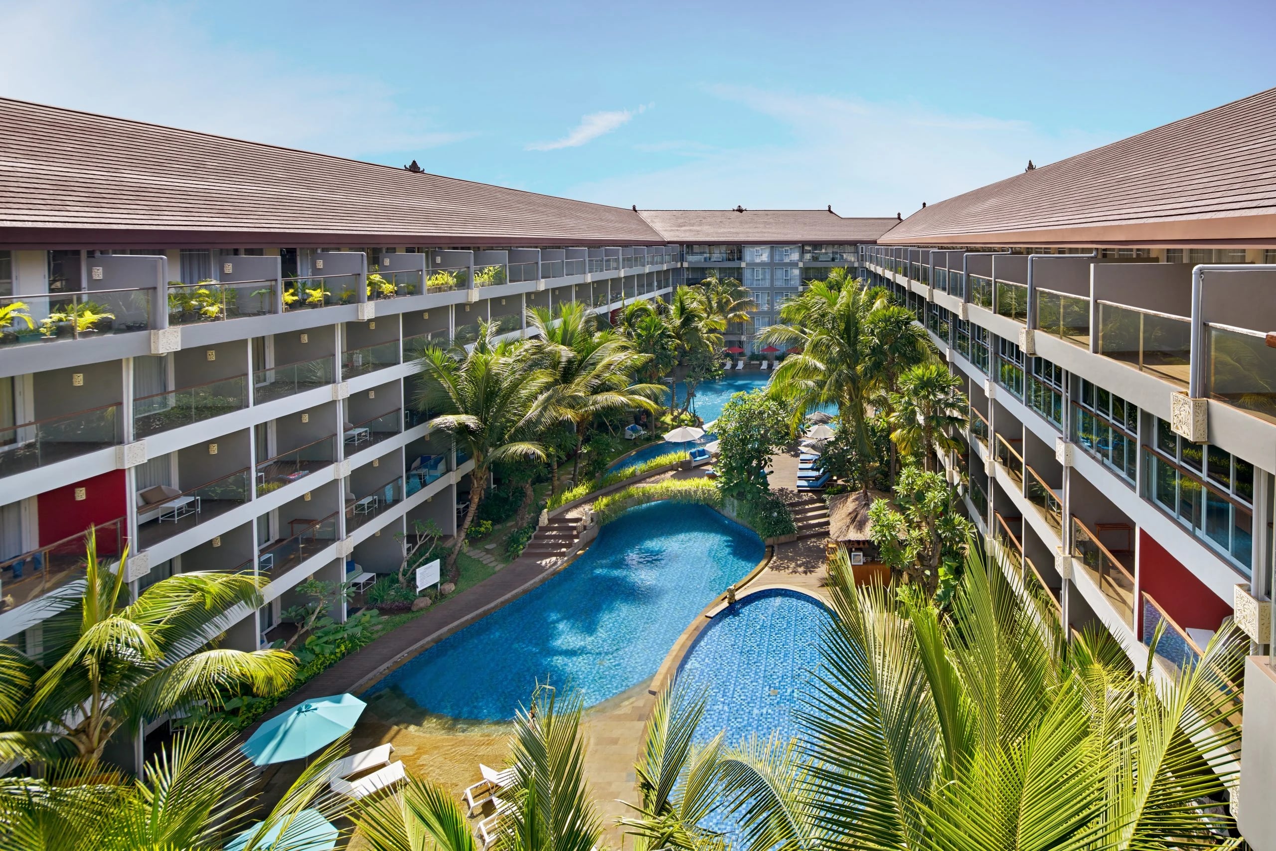 The lagoon pool at de Lagoon Seminyak Residence, framed by palms and resort balconies